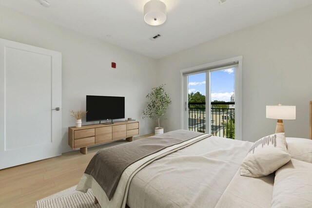 bedroom with visible vents, light wood finished floors, and access to exterior