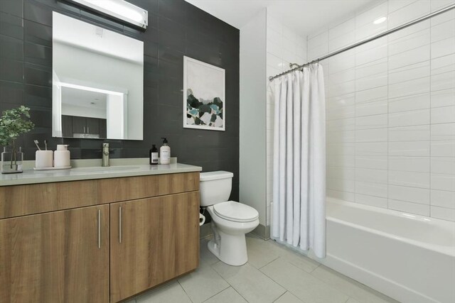 full bathroom with tile patterned flooring, shower / bath combination with curtain, toilet, and vanity