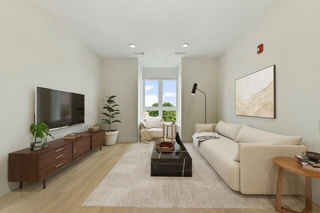 living room with recessed lighting, light wood-style flooring, and visible vents