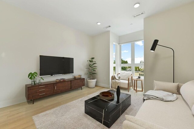 living room with recessed lighting, baseboards, light wood finished floors, and visible vents