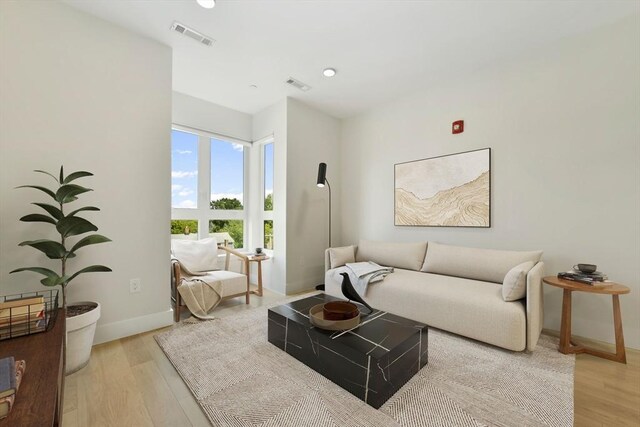 living room featuring baseboards, visible vents, and light wood-style floors