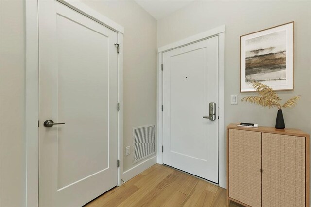 doorway featuring light wood-type flooring and visible vents