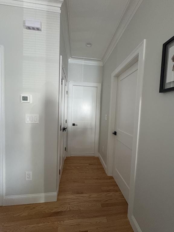 hall featuring wood-type flooring and crown molding