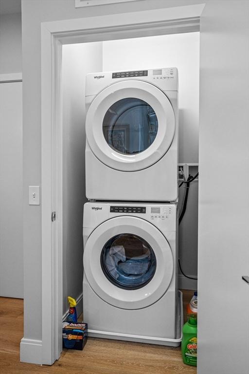 191 Washington St Unit 308, Boston, MA 02135 - laundry area featuring stacked washing machine and dryer and wood finished floors