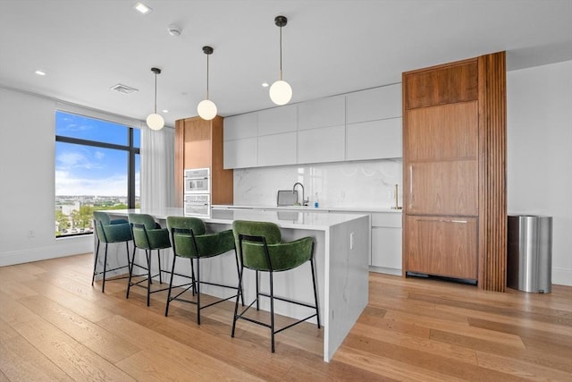 191 Washington St Unit 308, Boston, MA 02135 - kitchen with modern cabinets, a sink, light wood-style floors, light countertops, and recessed lighting