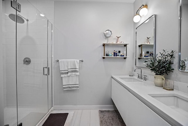 191 Washington St Unit 308, Boston, MA 02135 - bathroom featuring a stall shower, baseboards, and double vanity
