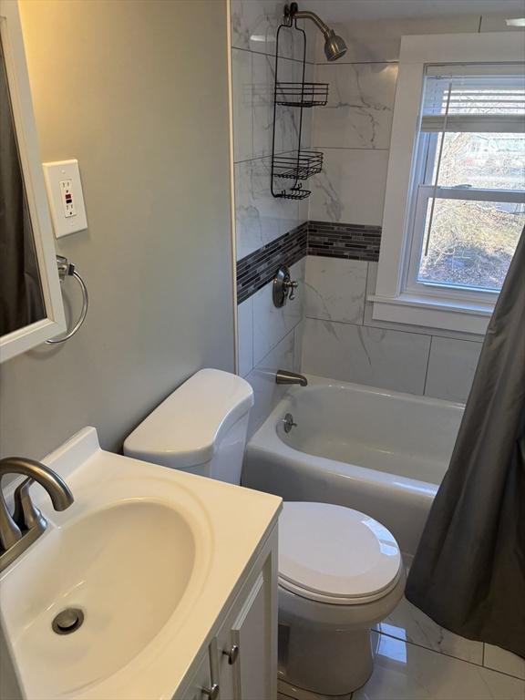 full bathroom featuring vanity, toilet, and shower / bathtub combination with curtain