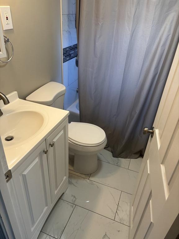 full bathroom with shower / bath combo, vanity, and toilet