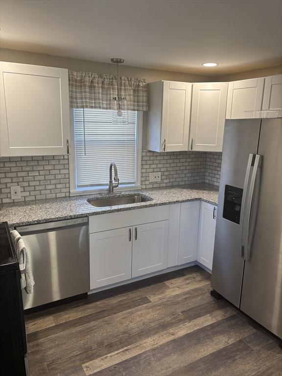 kitchen with white cabinets, appliances with stainless steel finishes, dark hardwood / wood-style flooring, and sink