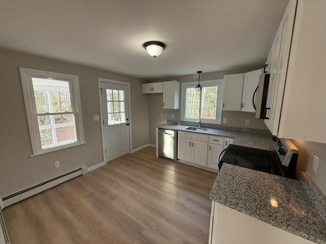 kitchen featuring appliances with stainless steel finishes, pendant lighting, white cabinets, a baseboard heating unit, and light stone countertops