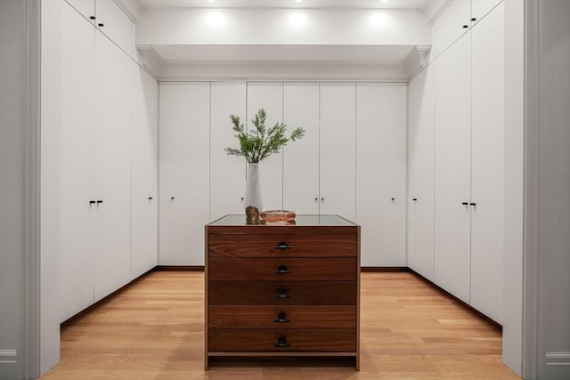 walk in closet with light hardwood / wood-style flooring