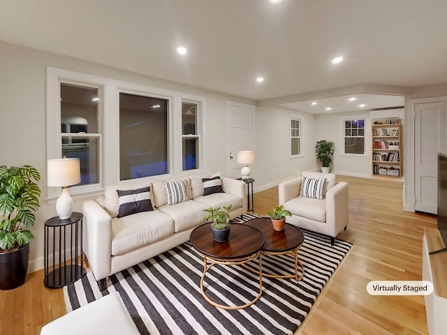 living room with recessed lighting, baseboards, and light wood-style floors