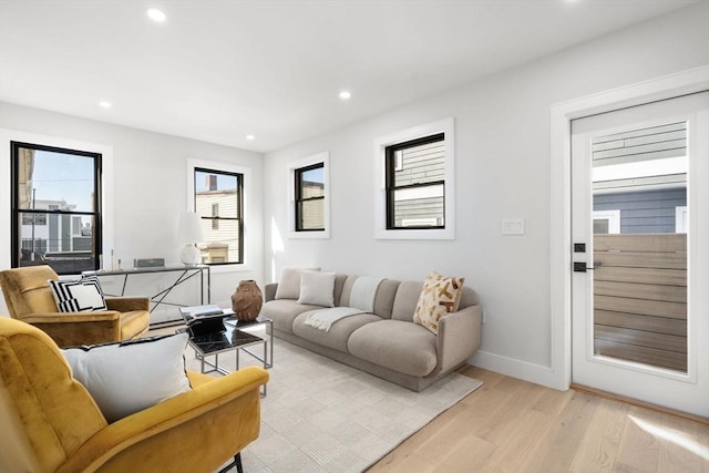 living room with light wood-style floors, baseboards, and recessed lighting