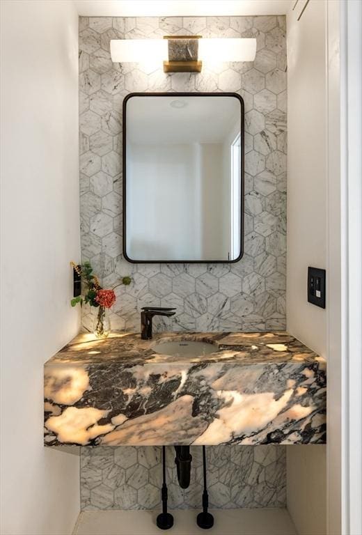 bathroom featuring tasteful backsplash and a sink