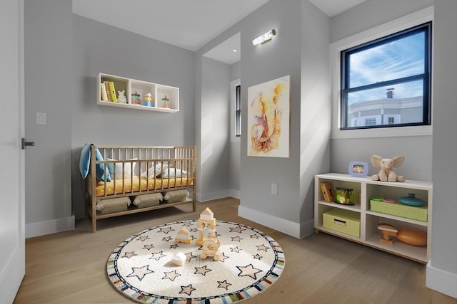 bedroom featuring wood finished floors and baseboards