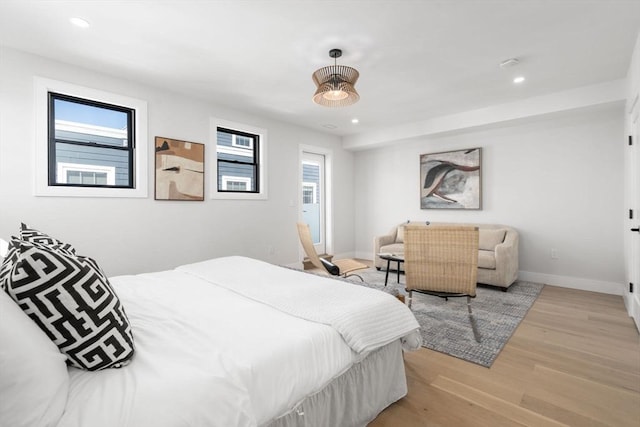 bedroom featuring light wood finished floors, multiple windows, baseboards, and recessed lighting