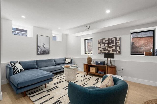 living room featuring baseboards, recessed lighting, and light wood-style floors