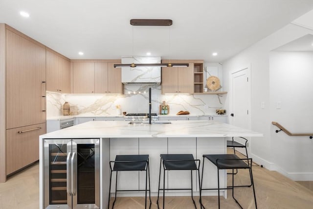 kitchen with light stone counters, beverage cooler, a kitchen bar, and tasteful backsplash