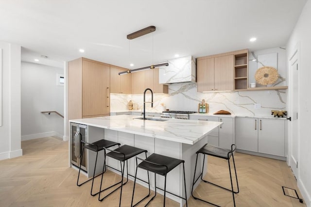 kitchen with a sink, open shelves, decorative backsplash, and light brown cabinetry