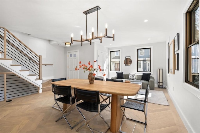 dining space featuring an inviting chandelier, baseboards, stairway, and recessed lighting