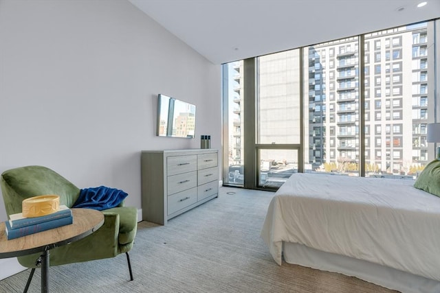 bedroom with expansive windows and light colored carpet