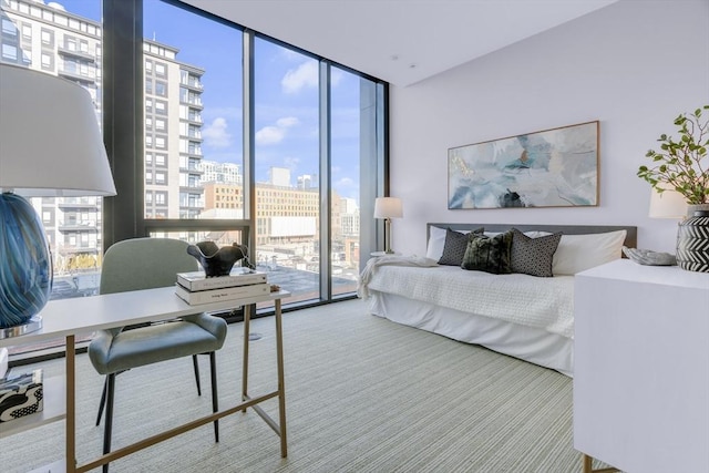 carpeted bedroom featuring a view of city, expansive windows, and access to exterior