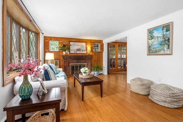 41 Sherrick Ave, Holbrook, MA 02342 - living room with light wood finished floors, a fireplace, wood walls, and french doors