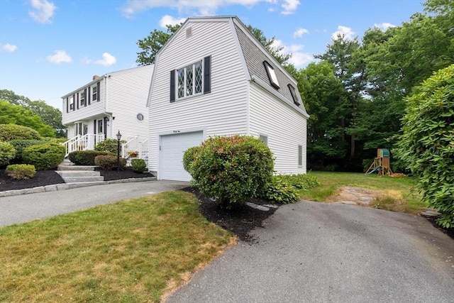 41 Sherrick Ave, Holbrook, MA 02342 - view of front facade featuring a garage, asphalt driveway, a front yard, a playground, and a gambrel roof