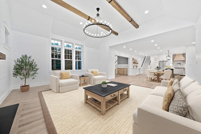 living room featuring lofted ceiling with beams, a chandelier, and light hardwood / wood-style floors