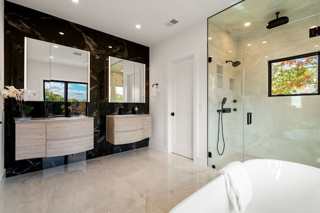 bathroom with tile walls, vanity, and plus walk in shower