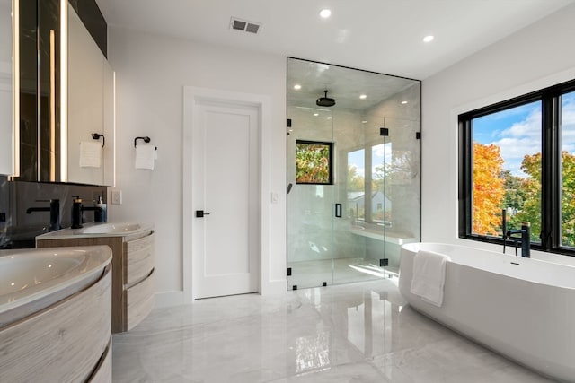 bathroom featuring vanity and independent shower and bath