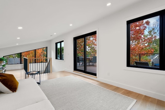 living room featuring lofted ceiling and light hardwood / wood-style floors