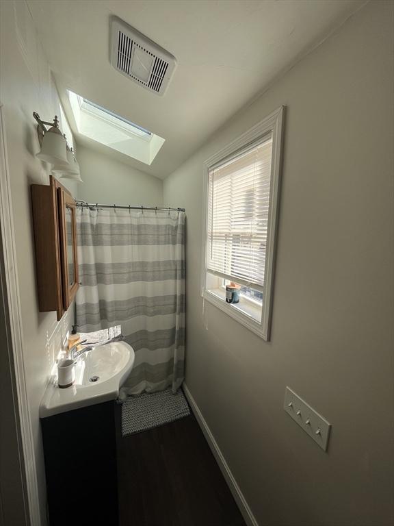 bathroom with hardwood / wood-style floors, vanity, and a shower with curtain