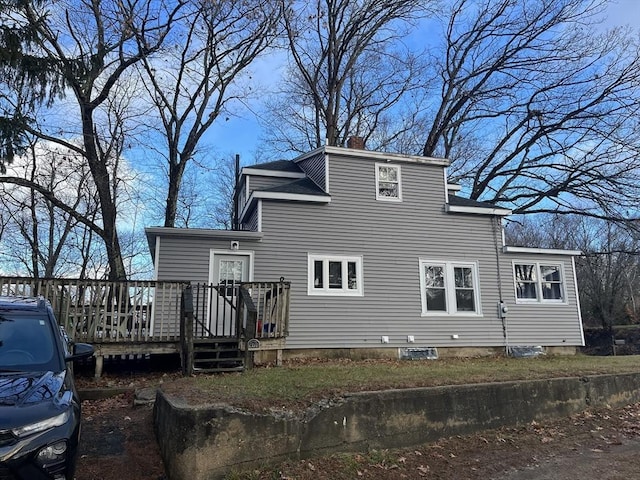 rear view of house featuring a wooden deck