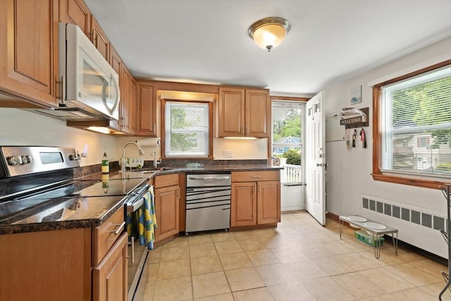 82 Brickel Rd, Stoughton, MA 02072 - kitchen with stainless steel appliances, radiator heating unit, plenty of natural light, and brown cabinetry