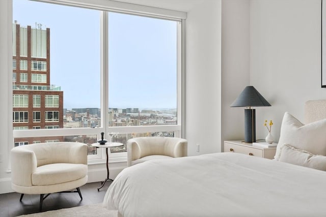 bedroom featuring a view of city and wood finished floors