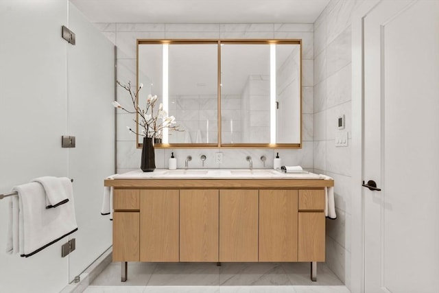 bathroom featuring a sink, tile walls, and double vanity