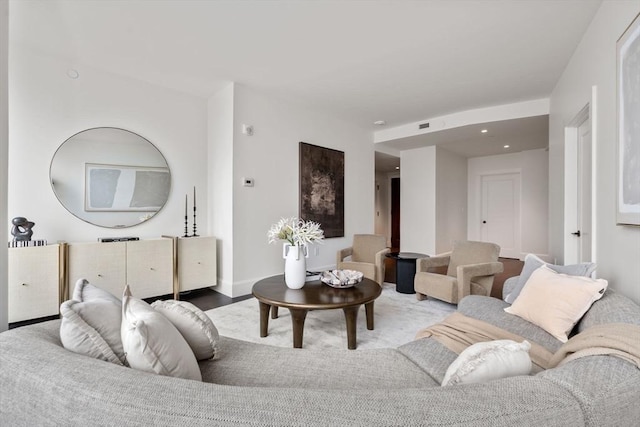 living room featuring visible vents, baseboards, and wood finished floors