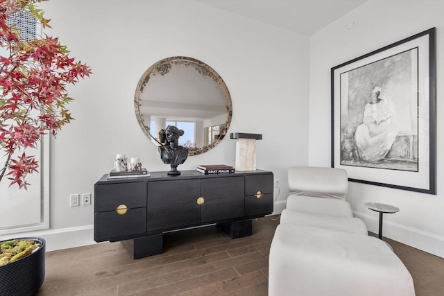 sitting room with dark wood-type flooring and baseboards