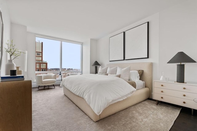 bedroom featuring expansive windows and wood finished floors