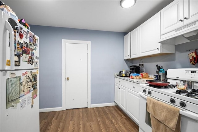 39 Worcester St, Southbridge, MA 01550 - kitchen featuring white appliances, dark wood-type flooring, light countertops, under cabinet range hood, and baseboards