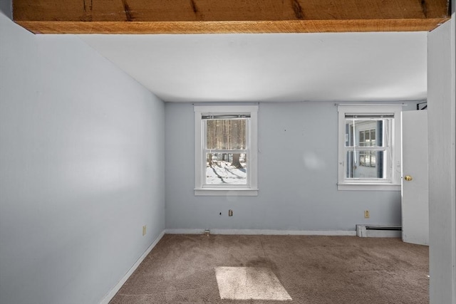 spare room with baseboards, baseboard heating, and carpet floors