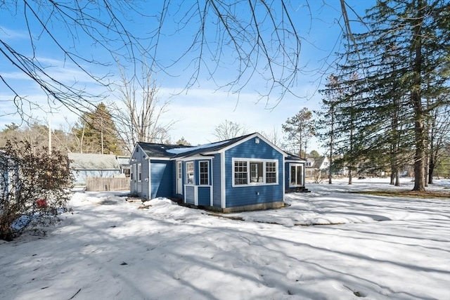 snow covered property with fence