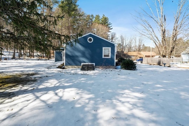 snow covered structure with fence