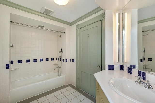 bathroom with tile patterned flooring, vanity, and tiled shower / bath