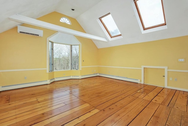 additional living space featuring hardwood / wood-style floors, lofted ceiling with skylight, and a wall mounted AC