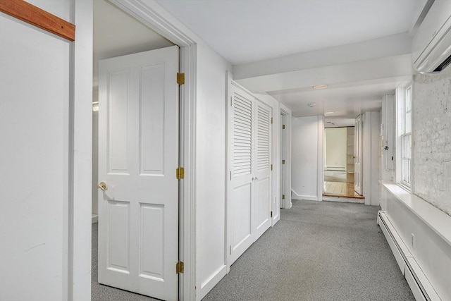 corridor with carpet flooring, a baseboard radiator, and a wall unit AC