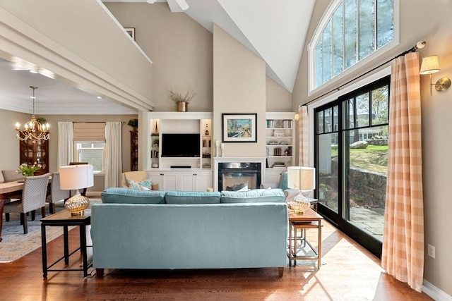 living room featuring high vaulted ceiling, wood finished floors, and a chandelier