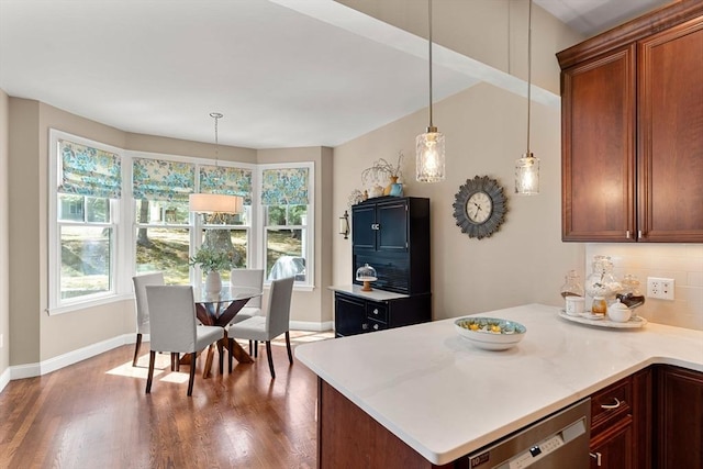 kitchen featuring a healthy amount of sunlight, baseboards, wood finished floors, and dishwasher