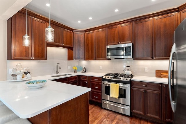 kitchen featuring a sink, light countertops, stainless steel appliances, and a peninsula